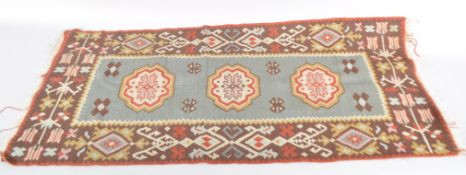 A small possibly Moroccan rug with blue rectangular panel,