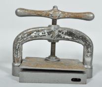 A vintage cast iron book press, painted in silver,