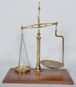 A pair of late 19th century brass scales, on mahogany plinth base,