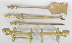 A pair of brass fire dogs and a companion set, 19th century,