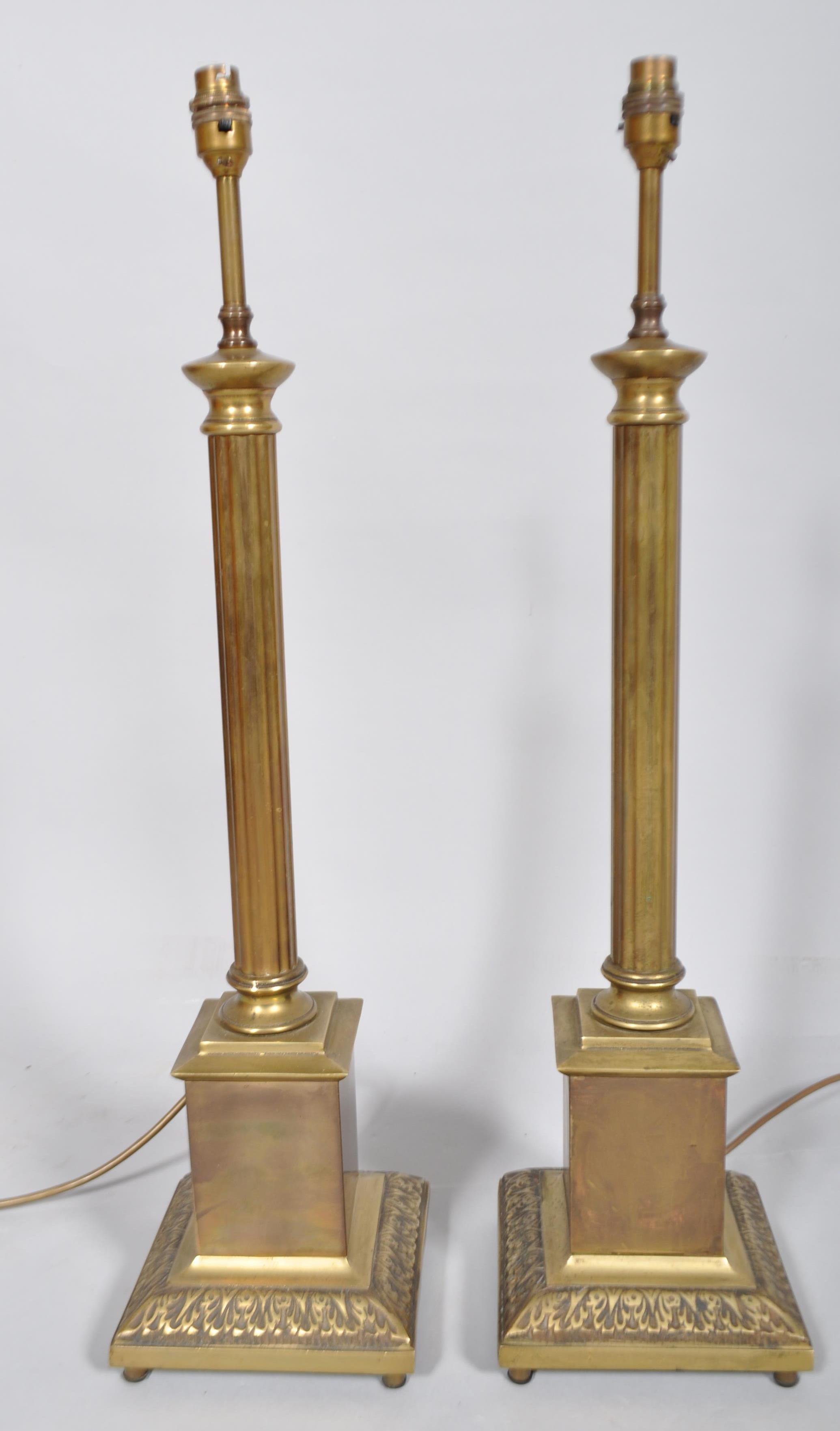 A pair of brass column lamp bases, 20th century, on square bases cast with acanthus leaves,