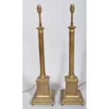 A pair of brass column lamp bases, 20th century, on square bases cast with acanthus leaves,
