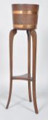 An R A Lister (Dursley) copper mounted mahogany jardiniere and plant stand,