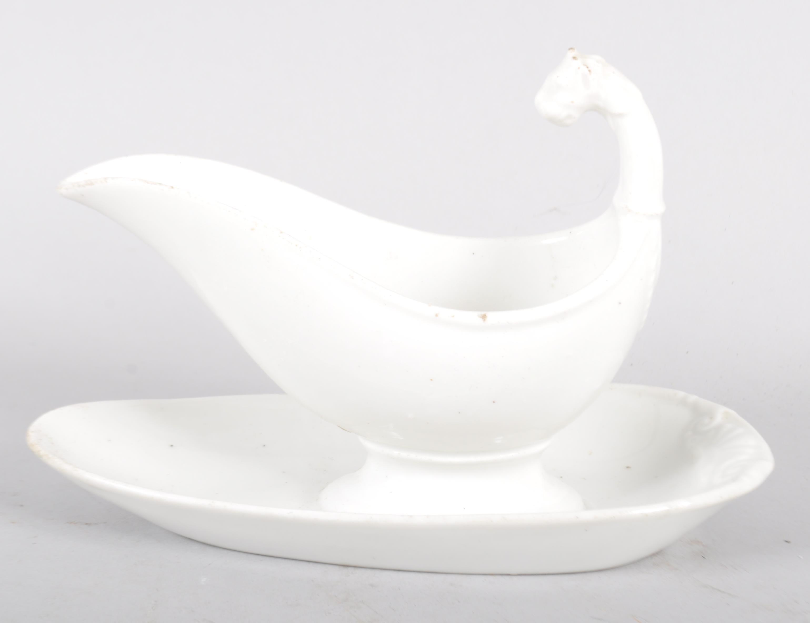 A Continental porcelain white sauce boat and stand, with lion terminal,