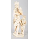 An early 20th century ivory Japanese Okimono of a father and child, the father holding a Noh mask,