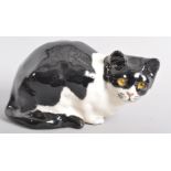 An English pottery model of a black and white cat in the Wemyss style, signed G.