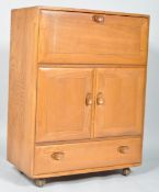 An Ercol pale Windsor bureau-drinks cabinet, 1960's, with fall front desk,