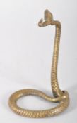 A Victorian-style brass stand modelled as a serpent partially coiled,