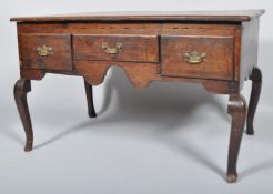 A George IV oak low boy having a flared top with three frieze drawers,