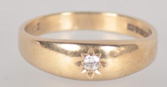 A yellow metal single stone ring.