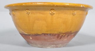 A 19th century terracotta diary bowl, with decorated prunts beneath a flared rim,