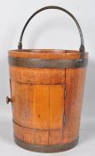 An early 19th century mahogany pot cupboard in the form of a large brass bound coopered peat bucket,