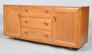 An Ercol pale elm Windsor sideboard, 1960's, with three central drawers flanked by two cupboards,