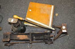 A collection of three car jacks together with a paper guillotine