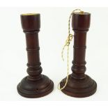 A pair of turned mahogany lamp bases, fitted for electricity, lacking tops