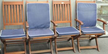 A set of four teak garden chairs