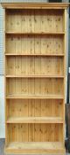 A pine bookcase with five shelves on plinth base