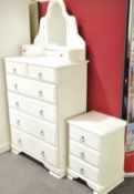 A white chest of drawers together with a bedside unit and mirror