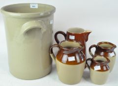 A collection of stoneware jugs and a large stoneware pot
