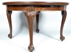 A mahogany extending dining table in the George III style, of circular form with one leaf,