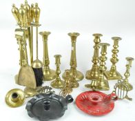 A brass fender a quantity of brass candlesticks and other items