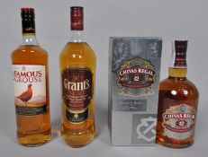 A bottle of Chivas Regal, a bottle of Famous Grouse whisky, and a bottle of Grants whisky