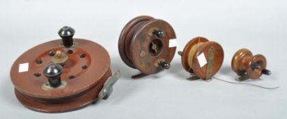 A box of four wooden centre pin fishing reels;