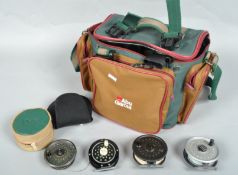 An Abu Garcia shoulder bag with a collection of fifteen trout fly reels and spare spools
