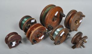 A box of seven wooden centre pin reels;