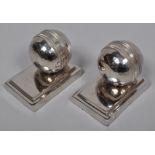 A pair of novelty silver metal cricket ball bookends,