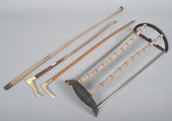 A small stick stand with bamboo uprights, together with three riding crops