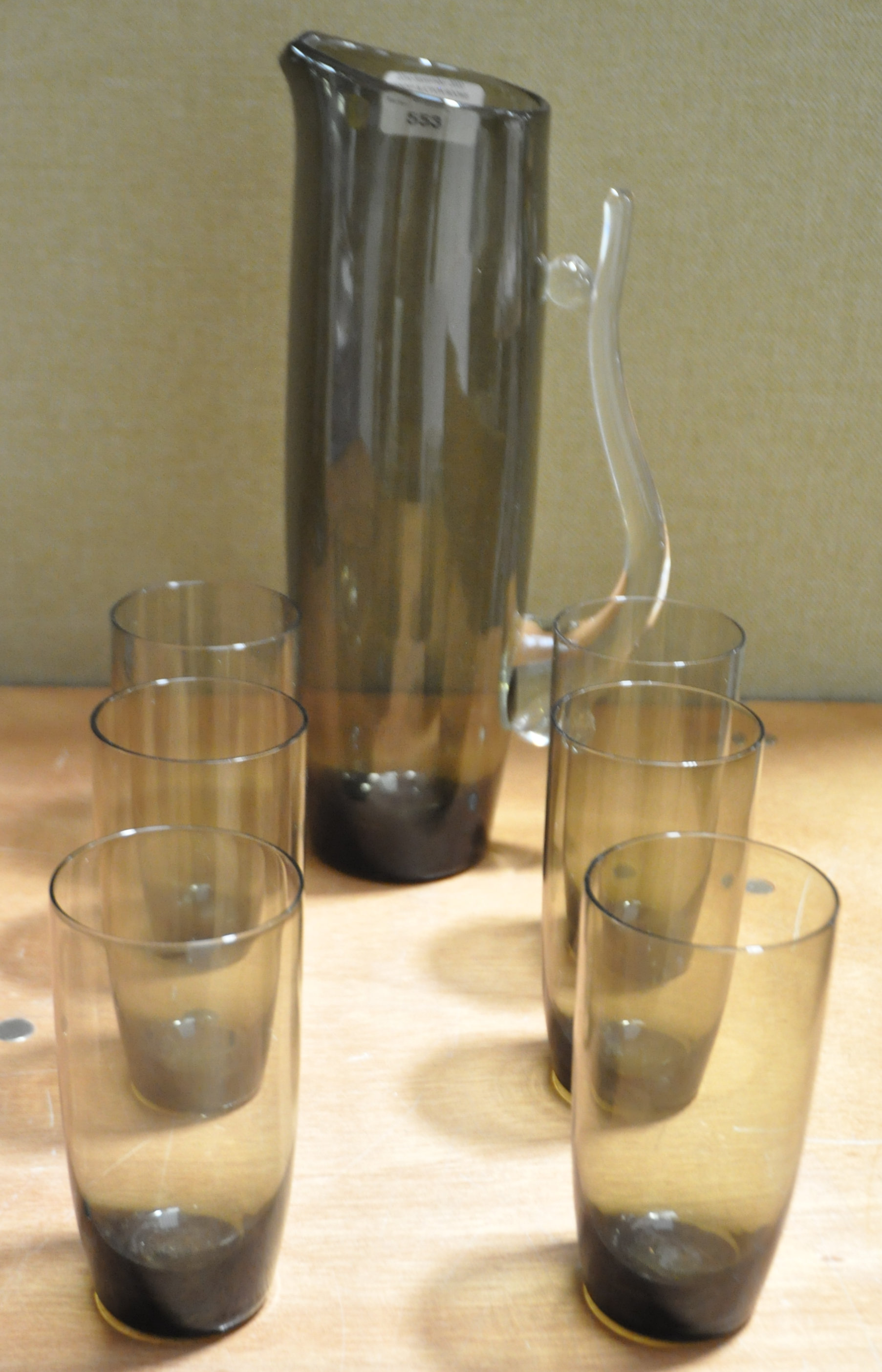 A lemonade set in smoked glass with shaped clear glass handle to the jug