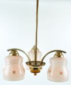 A 1930's three branch ceiling light, each pink glass light shade printed with a flower sprig,