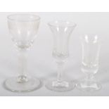 An 18th century wine glass with engraved bowl and two small bell-shaped sherry glasses (3) 11.5 cm.