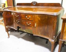 A mahogany serpentine fronted sideboard having gallery back,