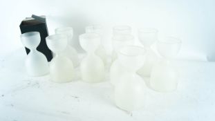 A quantity of boxed frosted glass carafes each in a hourglass form.