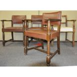 A set of four oak elbow dining chairs, having rexin studded upholstered seats,