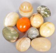 A collection of ten stone eggs of slight varying sizes and stones.