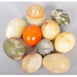 A collection of ten stone eggs of slight varying sizes and stones.