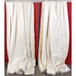 A pair of lined cream curtains with trassled edge.