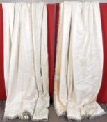 A pair of lined cream curtains with trassled edge.