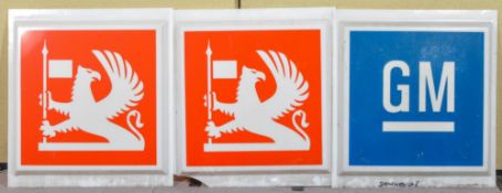 A pair of 1970's Vauxhall Griffin square light box signs with a GM sign