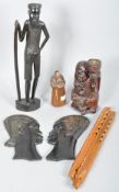 A collection of assorted carved wooden items to include; African male and female carved plaques,