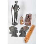 A collection of assorted carved wooden items to include; African male and female carved plaques,