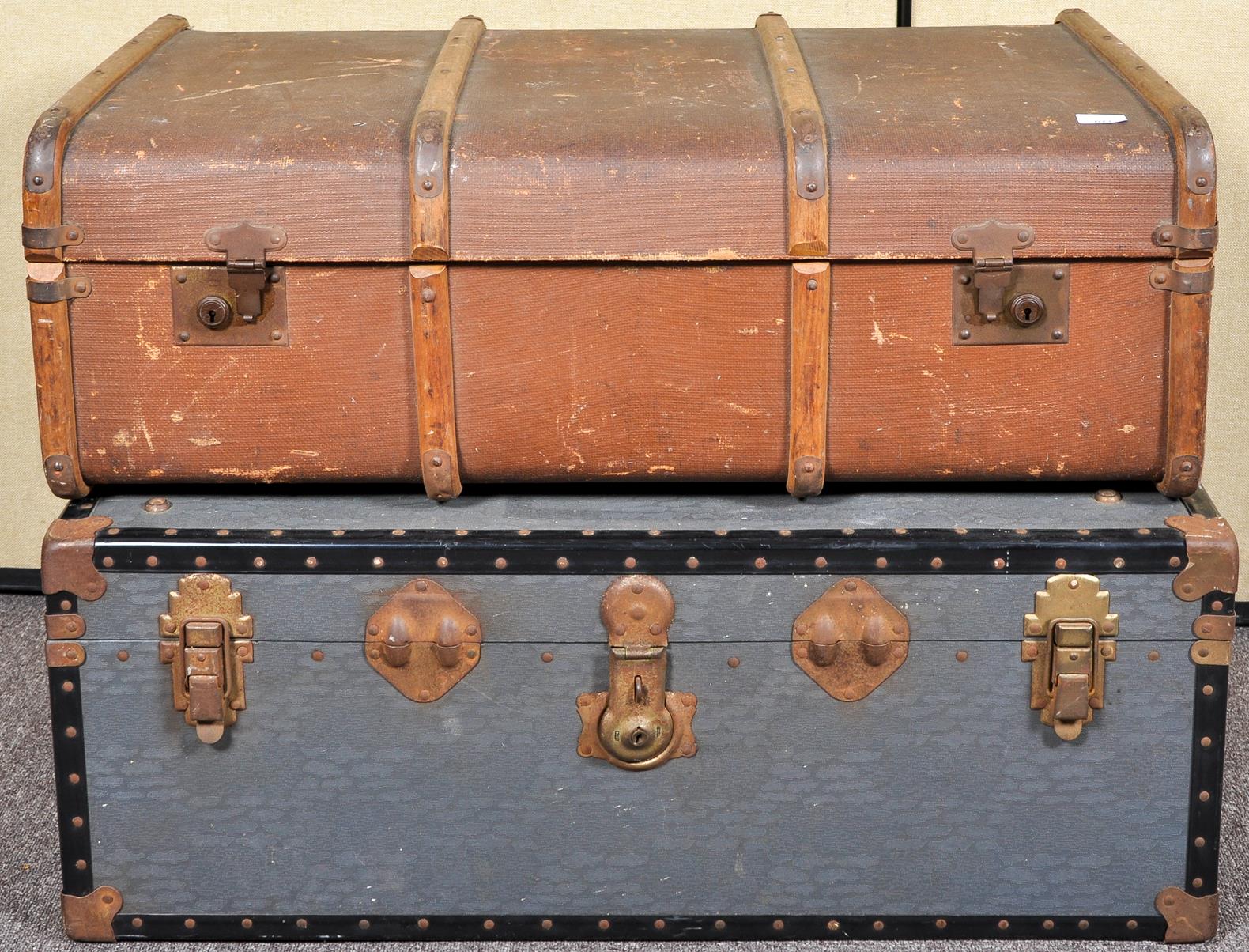 A canvas and wooden bound steamer trunk along with another trunk