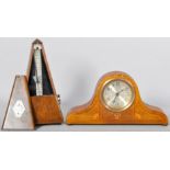 An Edwardian small mahogany and inlay Napoleon hat clock along with a metronome.