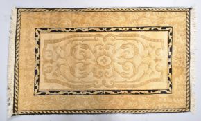 A small gold and ivory ground wool rug,