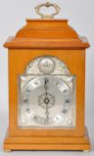 A Queens Jubilee mahogany mantel clock with silvered face, brass handle and bun feet.