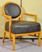 A contemporary Art Deco inspired oak lounge chair upholstered in faux leather. Measures; 86cm high.