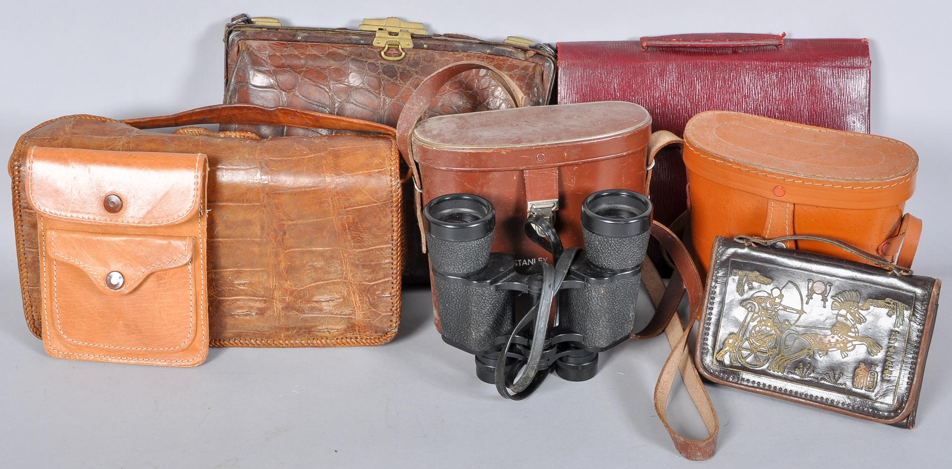 A collection of leather and crocodile skin bags along with two sets of cased binoculars